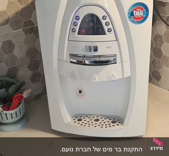 מכונת מים חמה על השיש במטבח